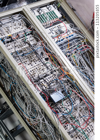 server room rack with tangled network cables creating messy untidy network system 113205855