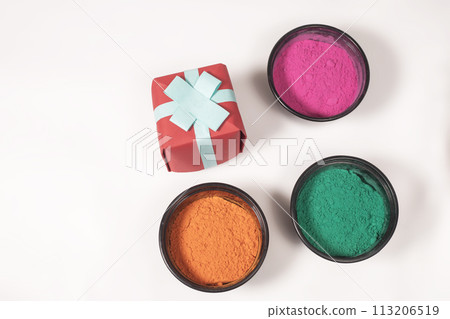 Colorful Holi powder with gift box on white background for Indian Holi festival celebration. Top view 113206519