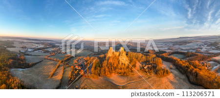 Trosky medieval castle ruins at cold morning sunrise time. Bohemian Paradise, Czech: Cesky raj, Czechia. Aerial view from above. 113206571
