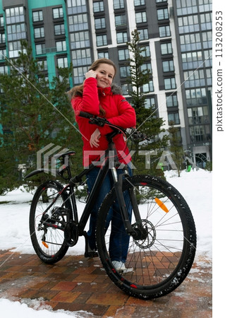 Caucasian woman rides a rented bicycle on a winter weekend Caucasian woman rides a rented bicycle on a winter weekend 113208253