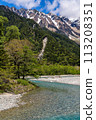 Fast flowing clear river running through a forest and mountains 113208351