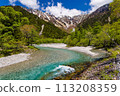 Beautiful clear river flowing towards snowcapped mountain peaks (Kamikochi, Nagano, Japan) 113208359