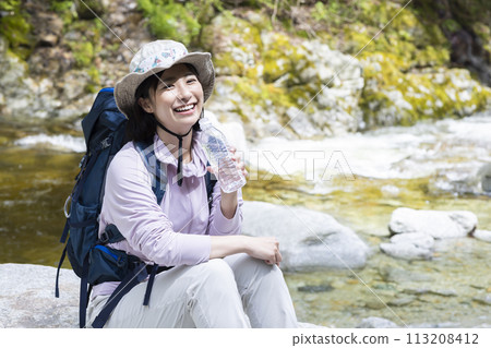 A woman enjoying a hike in fresh greenery 113208412