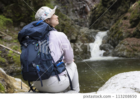 一位女士在新鮮的綠色植物中享受徒步旅行 113208650