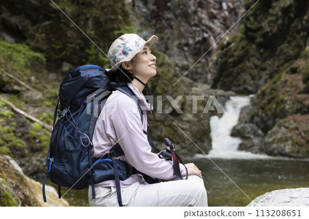 一位女士在新鮮的綠色植物中享受徒步旅行 113208651