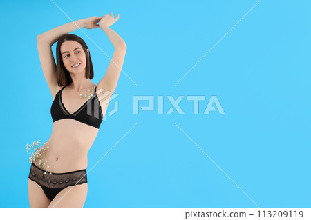 Slim girl in underwear with flowers, on a blue background. Slim girl in underwear with flowers, on a blue background. 113209119