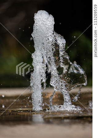 The momentary shape of water gushing out of a fountain 113209559