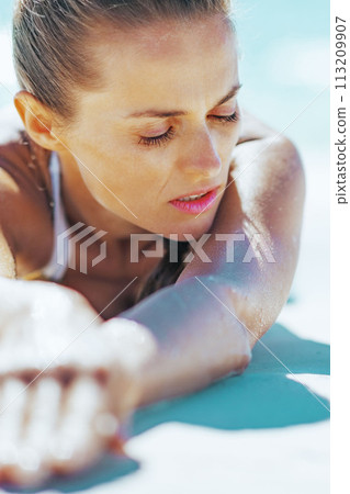 Relaxed young woman laying at seaside 113209907