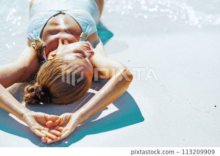 Young woman sunbathing on beach Young woman sunbathing on beach 113209909