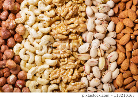 Mixed nuts as background, top view. Walnut, hazelnut, pistachio, cashew and almond nuts Mixed nuts as background, top view. Walnut, hazelnut, pistachio, cashew and almond nuts 113210163