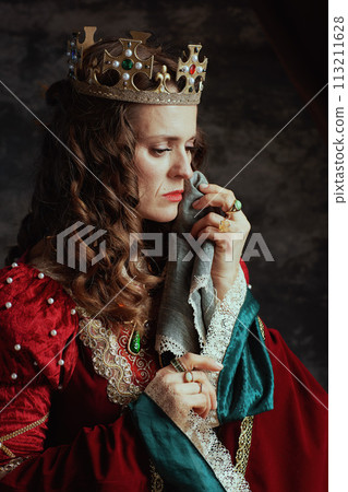 sad medieval queen in red dress with handkerchief crying 113211628