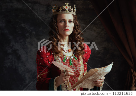 medieval queen in red dress with parchment and crown 113211635