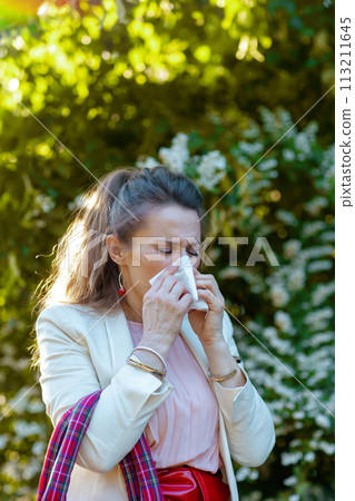 woman in dress and jacket in city has allergy attack 113211645