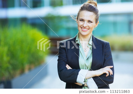 Portrait of happy modern woman worker near business center Portrait of happy modern woman worker near business center 113211863