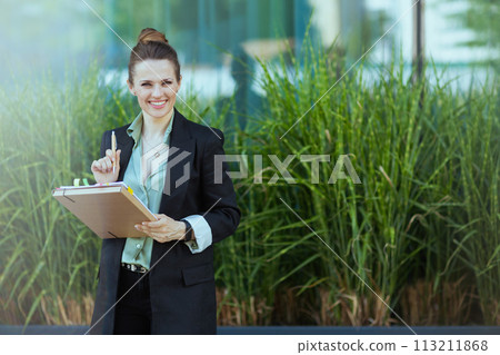 smiling modern business woman in business district 113211868