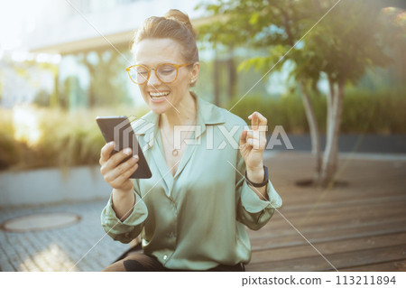 smiling modern woman worker in green blouse and eyeglasses 113211894