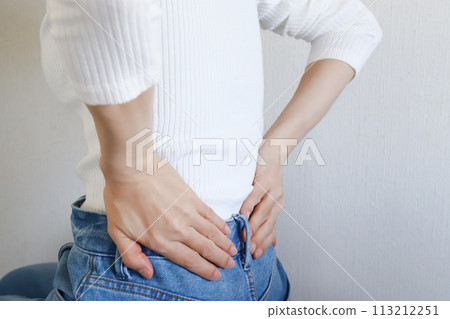 下背部疼痛-女人抱著她的下背部 下背部疼痛-女人抱著她的下背部 113212251