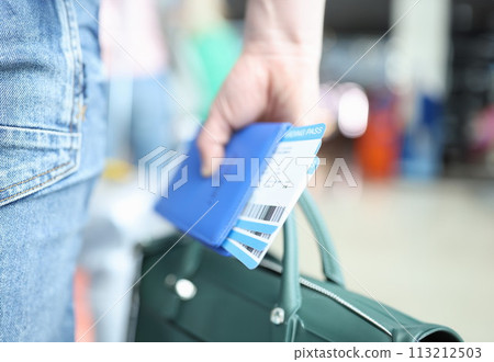 Man holding green briefcase and passport with plane tickets closeup Man holding green briefcase and passport with plane tickets closeup 113212503