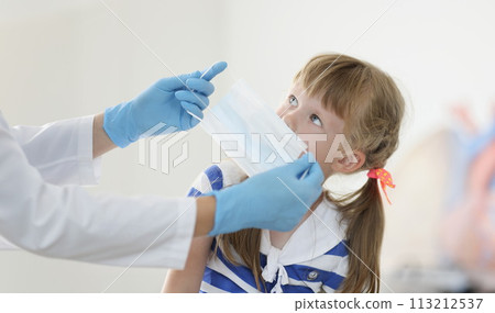 Doctor putting protective medical mask on little girl in clinic 113212537