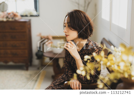 中年婦女坐在房間的沙發上 中年婦女坐在房間的沙發上 113212741