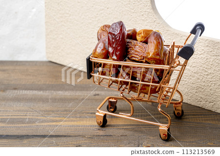 Close up shopping cart full of dates on a wooden desk. 113213569