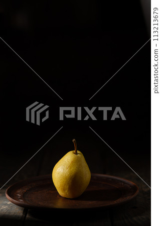 One yellow pear on a clay plate One yellow pear on a clay plate 113213679