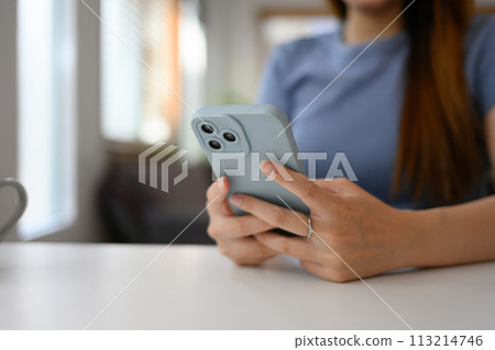 Closeup young woman typing massage on her mobile phone. People and technology concept Closeup young woman typing massage on her mobile phone. People and technology concept 113214746