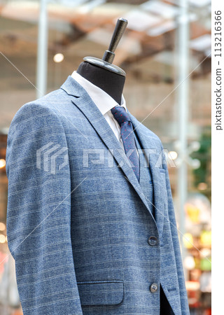 Male mannequin dressed in elegant suit with a tie in a clothing store 113216366