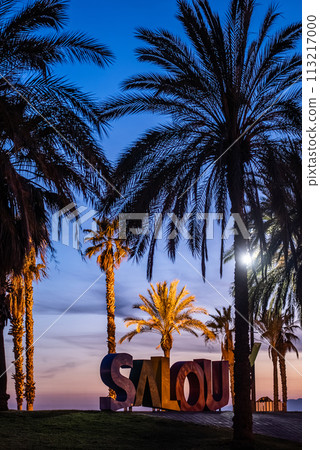 colorful letters of Salou town, palm trees andl beach at sunset, Catalonia, Spain 113217000