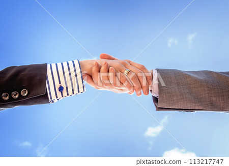 Closeup of business handshake over sky background Closeup of business handshake over sky background 113217747