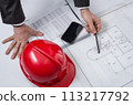 Above view of architect hands revising a house project 113217792
