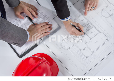 Above view of architects hands revising a house project 113217796