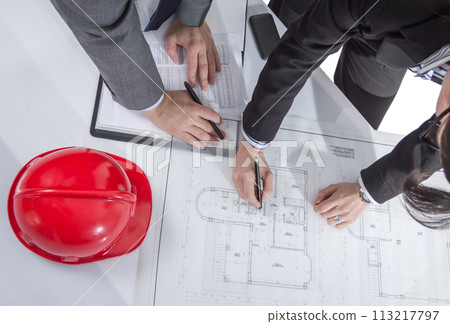 Above view of architects hands revising a house project 113217797