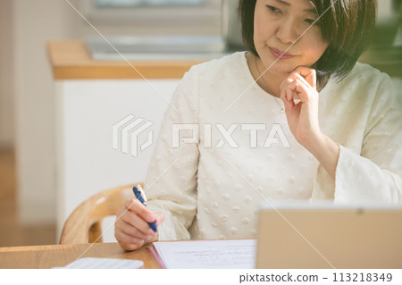 A woman worried while taking notes 113218349