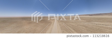 Panoramic drone picture of a lonely gravel road through the desert 113218616