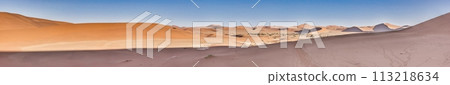 Panoramic picture of the red dunes of the Namib Desert with footprints in the sand against blue sky 113218634
