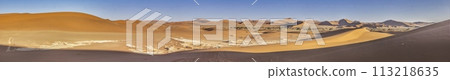 Panoramic picture of the red dunes of the Namib Desert with footprints in the sand against blue sky Panoramic picture of the red dunes of the Namib Desert with footprints in the sand against blue sky 113218635