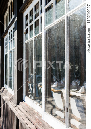 Retro wooden frame glass window, wine glasses and table setting 113219607