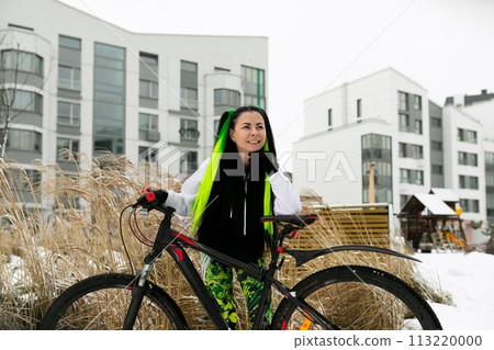 Woman Standing Next to Bike in Snow 113220000