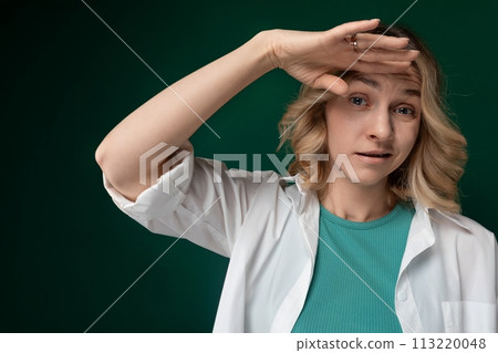 Woman in Green Shirt Holding Hands on Head Woman in Green Shirt Holding Hands on Head 113220048