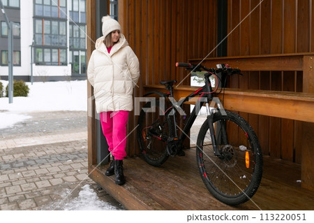 Woman Standing Next to Bike in Front of Building Woman Standing Next to Bike in Front of Building 113220051