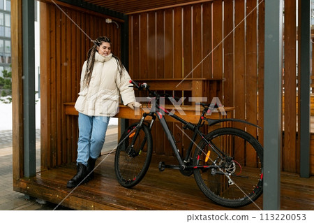 Woman Standing Next to Bike on Wooden Platform 113220053