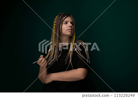 Woman With Dreadlocks in Front of Green Wall Woman With Dreadlocks in Front of Green Wall 113220249