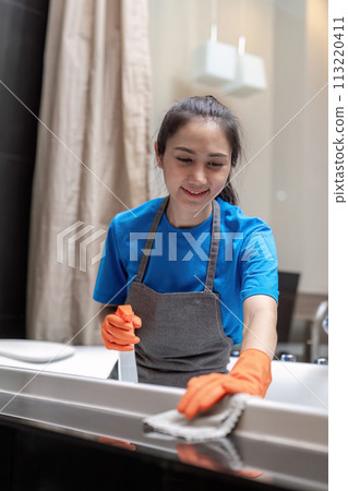 Professional cleaning service company employee in rubber gloves cleaning and detergent spray in bathroom Professional cleaning service company employee in rubber gloves cleaning and detergent spray in bathroom 113220411