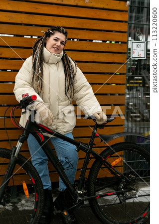 Woman With Dreadlocks Standing Next to Bike 113220600