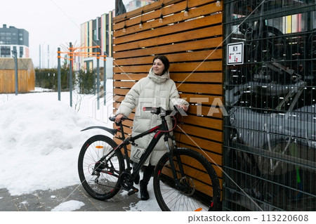 Woman in White Coat Standing Next to Bike Woman in White Coat Standing Next to Bike 113220608