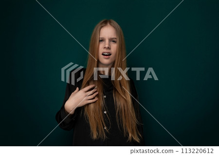 Woman With Long Red Hair Standing in Front of Green Wall 113220612
