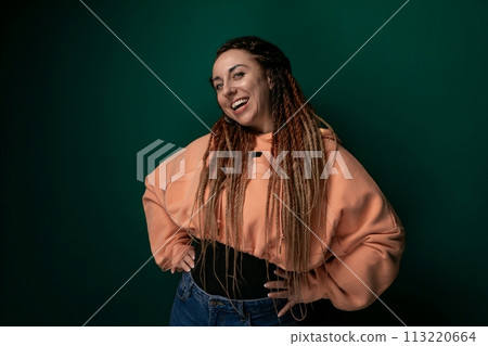 Woman With Dreadlocks Standing in Front of Green Background 113220664