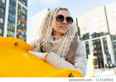 Woman With White Dreadlocks Leaning on Yellow Object 113220683