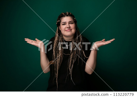 Woman With Dreadlocks Standing in Front of Green Wall 113220779